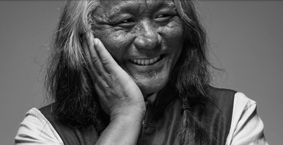 Black and white photo of Tenzin Choegyal smiling